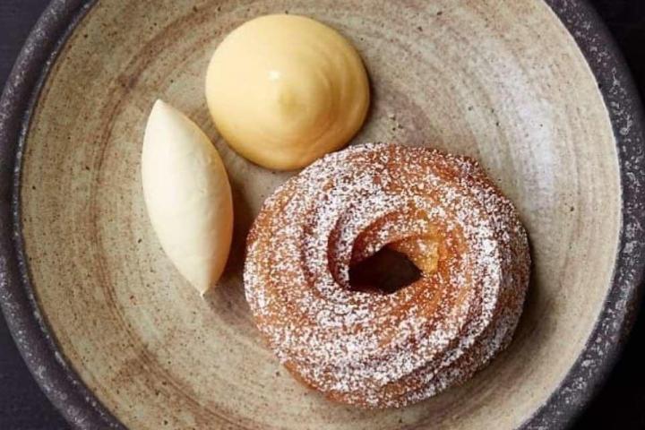 a doughnut sitting next to a cup of coffee