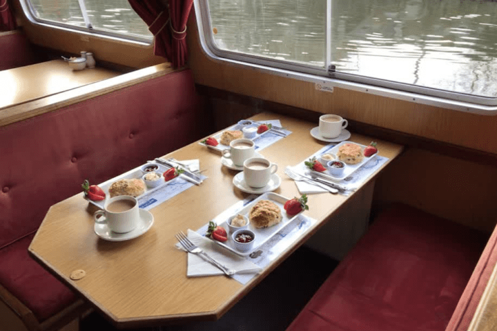 Tea and scones on a boat table with a water view.